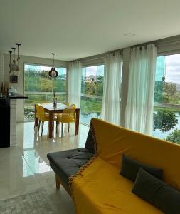 een woonkamer met een gele bank en een tafel bij Aconchego da serra in Bezerros