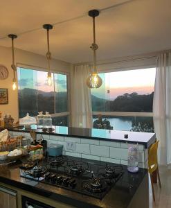 een keuken met een fornuis en een raam met uitzicht bij Aconchego da serra in Bezerros