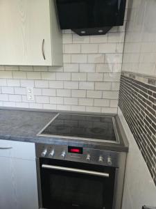 a stove top oven in a kitchen with white tiles at Ferienwohnung Alpencity in Garmisch-Partenkirchen