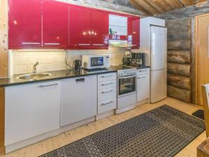 a kitchen with white appliances and red cabinets at Holiday Home Talles by Interhome in Saariselka +16 photos