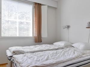 uma cama não feita num quarto branco com uma janela em Holiday Home Outapailakka j 12 by Interhome em Saariselka