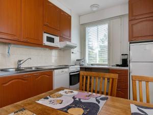 uma cozinha com armários de madeira e uma mesa de madeira com um lavatório em Holiday Home Outapailakka j 12 by Interhome em Saariselka