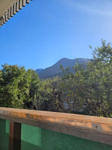 a view of the mountains from a wooden railing at Ferienwohnung Alpencity in Garmisch-Partenkirchen