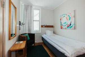 1 dormitorio con cama, escritorio y ventana en Gullmarsstrand Hotell & Konferens, en Fiskebäckskil