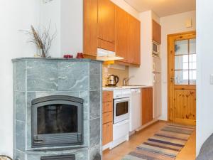 a kitchen with a fireplace in the middle of a room at Holiday Home Rautulampi g 20 by Interhome in Saariselka +3 photos