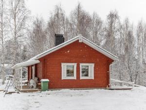 a small red brick house with snow on the roof at Holiday Home Käpälämäki by Interhome in Raanujärvi