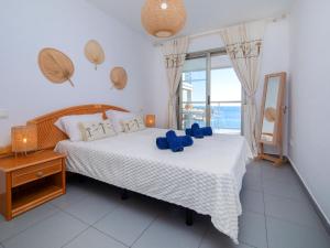 Un dormitorio con una cama con almohadas azules. en Apartment Sunseeker Hipocampos by Interhome en Calpe