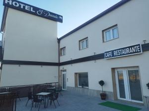 a hotel and workshop with tables and chairs in front of a building at Hotel El Duende in Madridejos