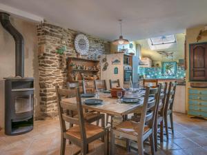 ein Esszimmer mit Tisch und Stühlen und einem Herd in der Unterkunft Holiday Home La Demeure Ty Ar Bleiz by Interhome in Sarzeau