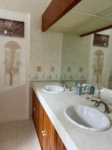 La salle de bains est pourvue de 2 lavabos et d'un grand miroir. dans l'établissement VILLA AMATE DORADO, à Xochitepec