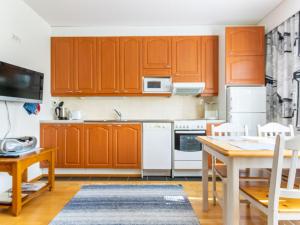 a kitchen with orange cabinets and a table and chairs at Holiday Home Outapailakka j 9 by Interhome in Saariselka