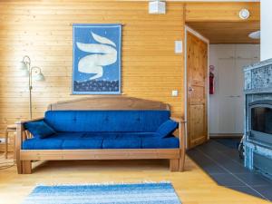 ein blaues Sofa in einem Zimmer mit Kamin in der Unterkunft Holiday Home Outapailakka j 9 by Interhome in Saariselkä