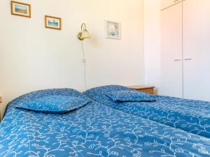 ein Bett mit blauer Decke in einem Schlafzimmer in der Unterkunft Holiday Home Outapailakka j 9 by Interhome in Saariselkä