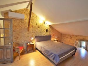1 dormitorio con cama y pared de piedra en Holiday Home Maison du Bourg by Interhome, en Lacapelle-Biron