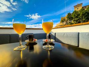two glasses of beer sitting on a table on a balcony at MEQUEDO CALDEREROS 25 in Alcañiz