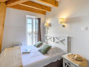 a bedroom with a white bed and a window at Apartment Le Château de Kergonano-13 by Interhome in Baden