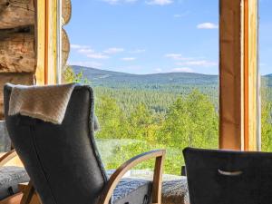 a window with two chairs and a view of the mountains at Holiday Home Uuvana by Interhome in Saariselka +24 photos