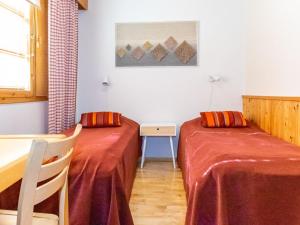 two beds in a room with a table and chairs at Holiday Home Teerenpesue e 38 by Interhome in Saariselka