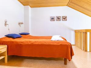 a bedroom with an orange bed with two pillows at Holiday Home Teerenpesue e 38 by Interhome in Saariselka +5 photos