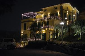 um edifício decorado com luzes de Natal à noite em Hotel Ca' di Gali em Sasso Marconi