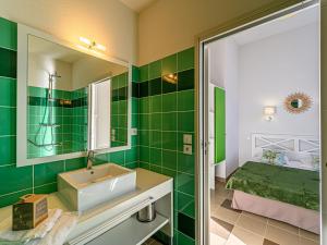 a green bathroom with a sink and a bed at Apartment Château De Kergonano-11 by Interhome in Baden