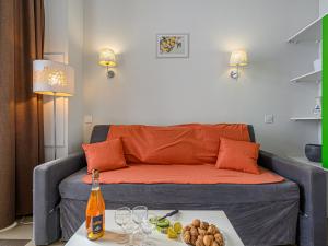 - un salon avec un canapé et une table avec une bouteille de vin dans l'établissement Apartment Le Château de Kergonano-11 by Interhome, à Baden