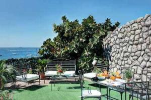 a patio with a table and chairs and the ocean at Ginestra beach suite in Massa Lubrense