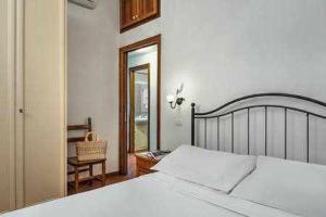 una camera con un grande letto bianco e una sedia di Ginestra beach suite a Massa Lubrense