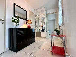 Una sala de estar con una cómoda negra y un espejo. en Holiday Home Joannie by Interhome, en Saint-Brevin-les-Pins