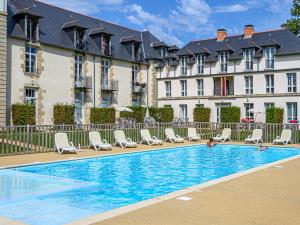 Una piscina frente a un edificio con tumbonas. en Apartment Château De Kergonano-19 by Interhome, en Baden