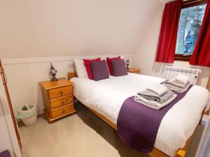 two beds in a small room with red curtains at Chalet Lodge 26 by Interhome in Spean Bridge