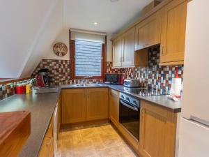 a kitchen with wooden cabinets and a sink and a stove at Chalet Lodge 26 by Interhome in Spean Bridge