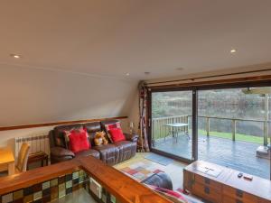 a living room with a couch and a large window at Chalet Lodge 26 by Interhome in Spean Bridge