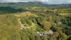 an aerial view of a house on a hill with trees at Cobleland Campsite in Gartmore