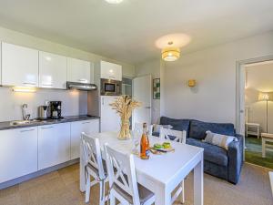 cocina y sala de estar con mesa blanca y sillas en Apartment Le Château de Kergonano-7 by Interhome en Baden