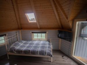 Cama en habitación pequeña con 2 ventanas en Chalet Corbet by Interhome en Drumnadrochit