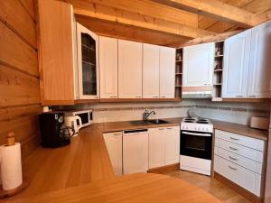 a kitchen with white cabinets and a stove top oven at Holiday Home Jytilevi a by Interhome in Sirkka