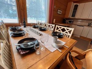 una mesa de madera con platos y copas de vino. en Holiday Home Jytilevi a by Interhome, en Sirkka