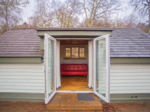 a garage with a red couch inside of it at Chalet Cobbs by Interhome in Drumnadrochit