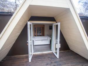 uma porta aberta para um quarto com uma cama numa tenda em Chalet Nessie 1 by Interhome em Drumnadrochit