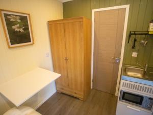 uma pequena cozinha com um lavatório e um armário em Chalet Nessie 1 by Interhome em Drumnadrochit
