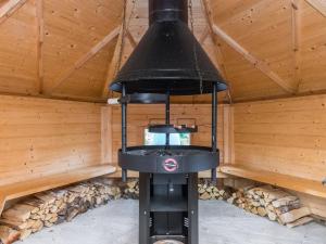 una estufa negra en una sauna con paredes de madera en Holiday Home Maitoniemi by Interhome, en Tirva