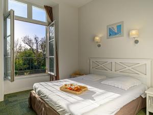 a bedroom with a bed with a tray of fruit on it at Apartment Le Château de Kergonano-8 by Interhome in Baden