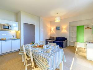 Una cocina y una sala de estar con una mesa y un sofá. en Apartment Le Château de Kergonano-8 by Interhome, en Baden