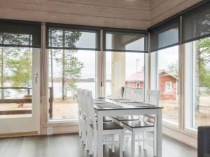 une salle à manger avec des chaises blanches, une table et des fenêtres dans l'établissement Holiday Home Taimen by Interhome, à Hailuoto 18 autres photos