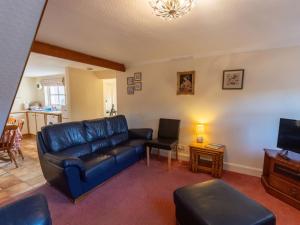 a living room with a blue couch and a tv at Holiday Home Lodge Road-2 by Interhome in Inverness