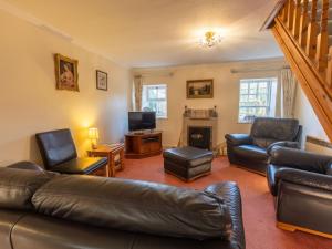 a living room with a leather couch and chairs at Holiday Home Lodge Road-2 by Interhome in Inverness