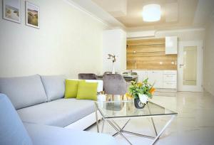 een woonkamer met een bank en een glazen tafel bij Sea View Apartment with Free Parking in Pomorie