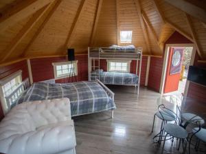 a attic room with two bunk beds and a table at Chalet Campbell by Interhome in Drumnadrochit