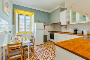 a kitchen with a table and a white refrigerator at A Casa Amarela de Sintra in Sintra